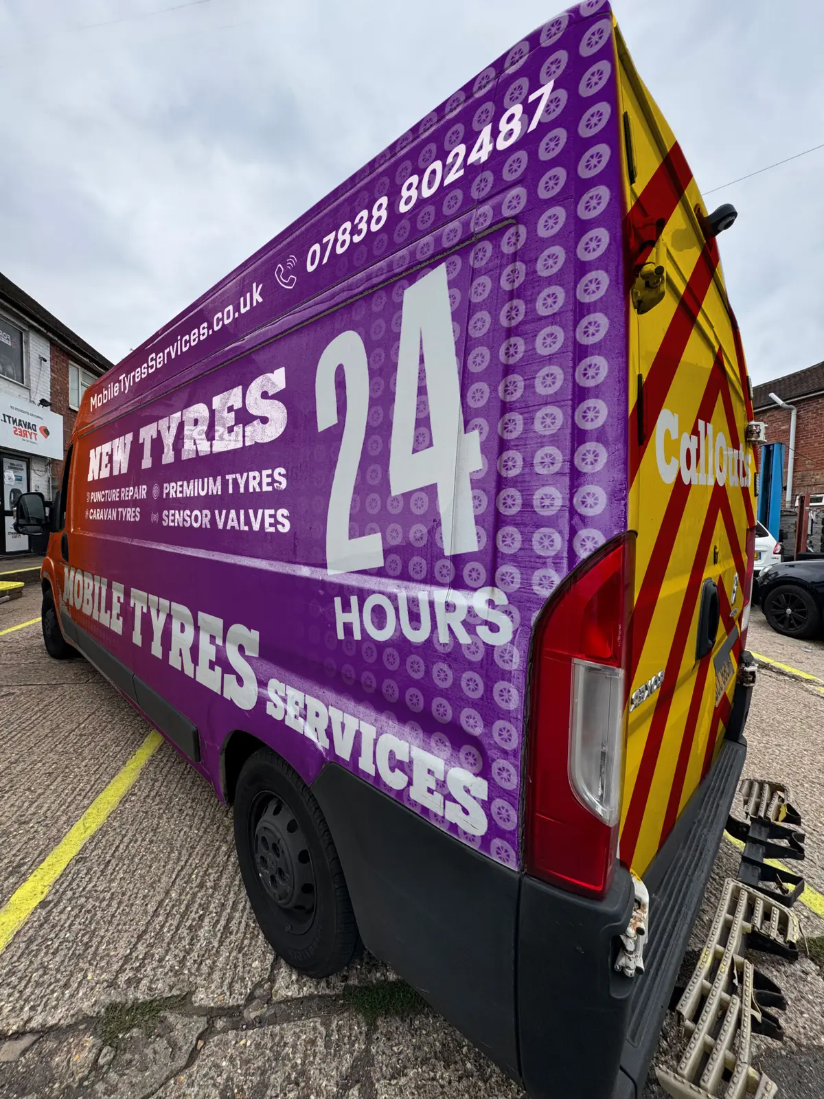 Rear of the purple Mobile Tyres Services van with 24 hours livery parked on a London street