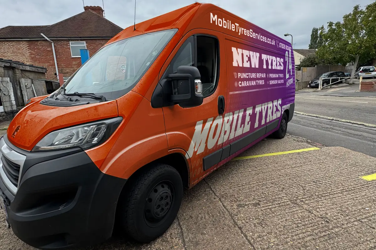 Orange and purple Mobile Tyres Services van parked on a residential street
