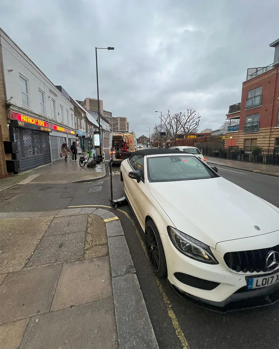 White Mercedes C-Class convertible at the kerb on a London high street